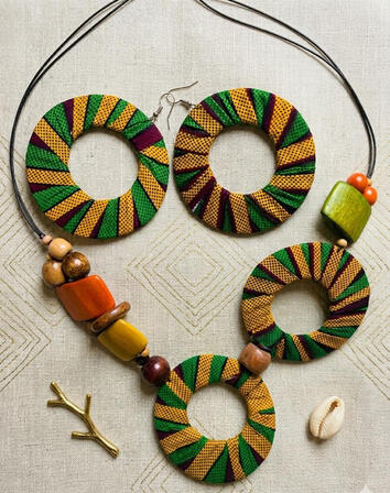 Nr. 4 Afrokubanische Ankara Halskette mit Doppelkreis Anhänger und Holzperlen. Intensive Farben treffen auf natürliche Materialien und schaffen ein ausdrucksstarkes Design mit Charakter. Perfekt als Blickfang.